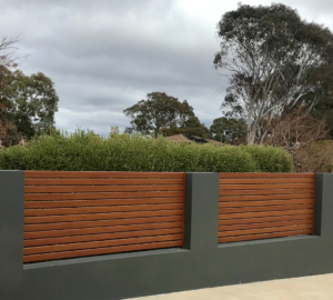 καγκελο περιφραξησ απο wpc σε καφε χρώμα πανω σε γκρι τοιχίο.