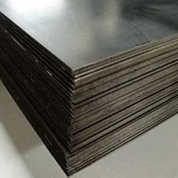 Στοίβα από μαύρες λαμαρίνες σιδήρου σε βιομηχανικό χώρο αποθήκευσης.